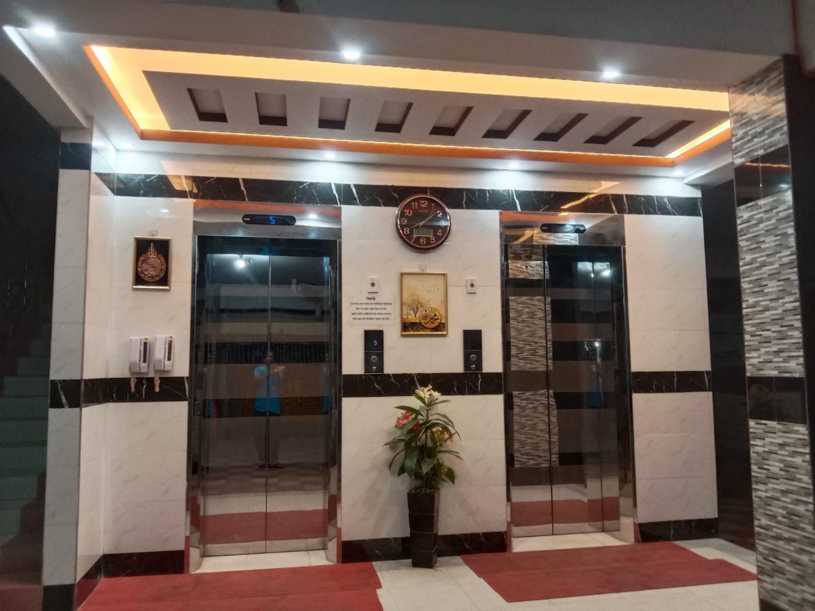 Warm, brass-lit elevator lobby with marble tiling — an interior fit-out by SAZ Commodities & Services